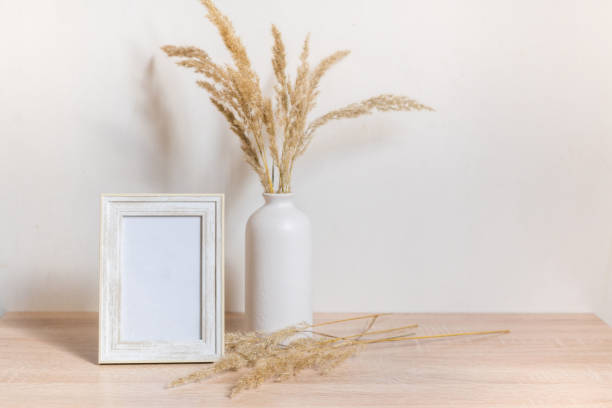 Portrait frame mock up with dried flowers on wooden table