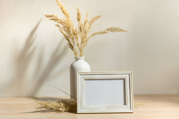 istock Portrait frame mock up with dried flowers on wooden table 1371075687