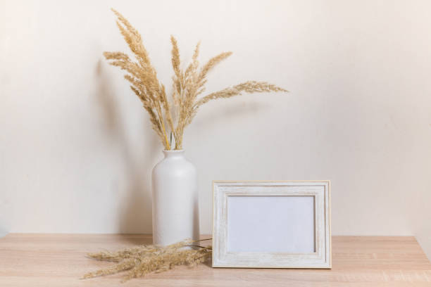 istock Portrait frame mock up with dried flowers on wooden table 1371075754