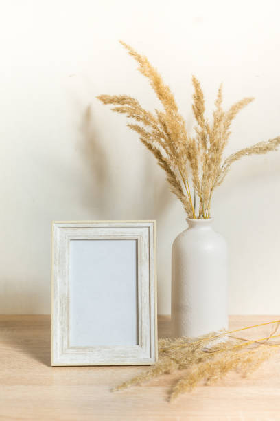 istock Portrait frame mock up with dried flowers on wooden table 1371075755