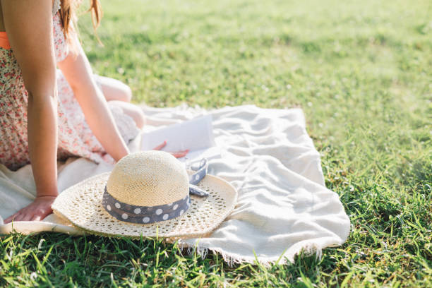 Close up of beautiful young woman reading a book in a park.
