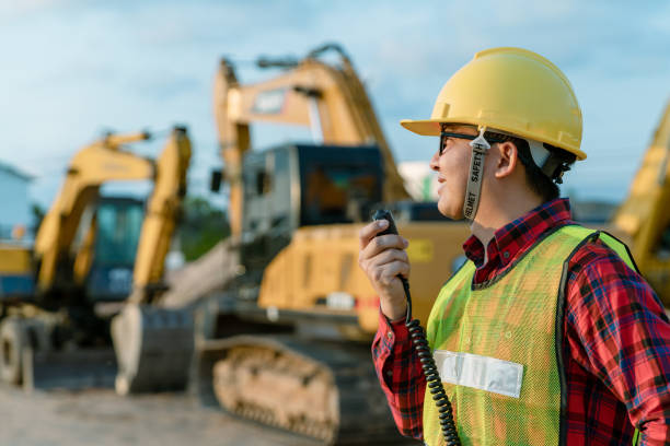 istock Engineer wear safety uniform inspection civil work. Construction engineer supervisor use walkie talkie for manage excavator. asian technician use technology for work today. 1371077221