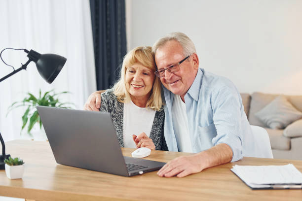 Having online conversation. Senior man and woman is together at home stock photo