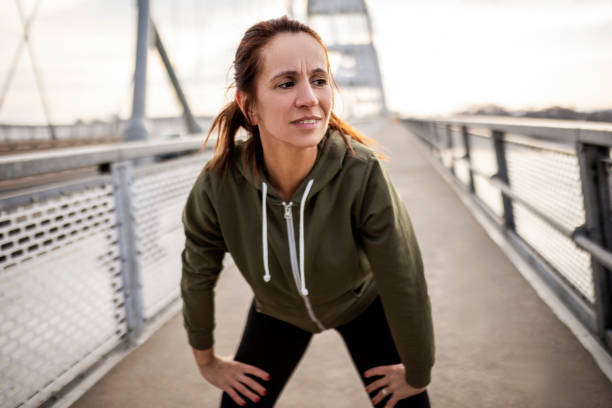 istock Sportswoman taking a break after running 1371081074