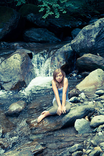 chica joven sentada en una cascada. - waterfall zen like women meditating fotografías e imágenes de stock