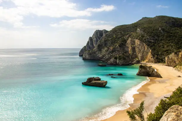 Beach in Sesimbra, Portugal with sky blue water
