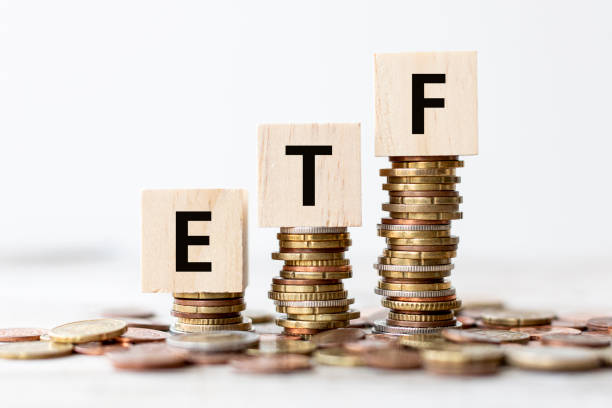 Concept - ETF Exchange Traded Fund wording on wooden cubes with coins Exchange Traded Fund (ETF) concept. Wooden cube standing with "ETF" text. "nWhite background, copy space. exchange traded fund stock pictures, royalty-free photos & images