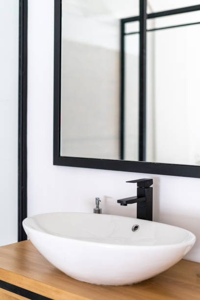 White round sink in modern bathroom with mirror Nordic style bathroom interior design with white round sink and mirror. Contemporary minimalistic hotel room. Cleanliness concept. Flat after renovation bathroom sink stock pictures, royalty-free photos & images