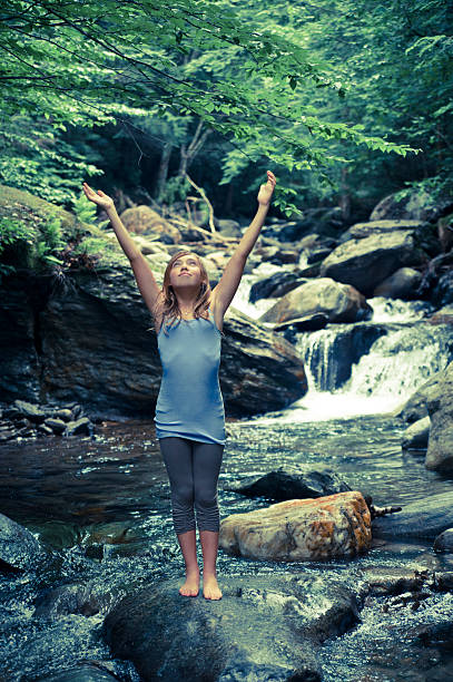 chica joven disfrutando de la naturaleza en una cascada. - waterfall zen like women meditating fotografías e imágenes de stock