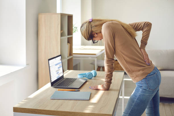 frau, die die ganze zeit in sitzender haltung an ihrem computer arbeitet, leidet unter rückenschmerzen - back rear view pain backache stock-fotos und bilder