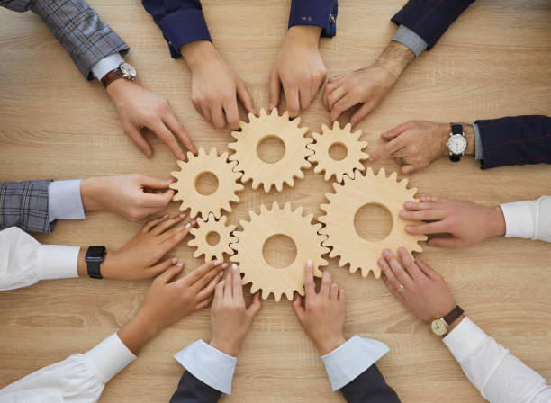 istock Team of people join cogwheels as metaphor for teamwork and effective business system 1371085416