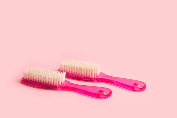 dos cepillos de uñas rosas sobre fondo rosa - scrub brush fotografías e imágenes de stock