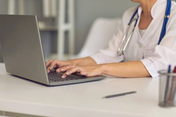 istock Concept doctor online. Doctor's hands are typing on a laptop keyboard a message web chat consultation medical clinic. 1371088047