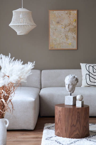 istock Stylish interior with design neutral modular sofa, mock up poster frames, coffee tables, dried flowers, decoration, pendant lamp and elegant personal accessories in modern home decor. Template. 1371088364