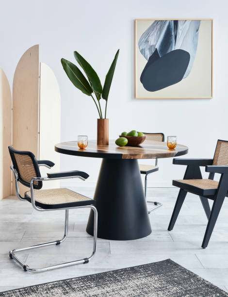istock Stylish composition of dining room interior with design table, modern chairs, decoration, tropical leaf in vase, fruits, carpet, abstract mock up paintings and elegant accessories in home decor. 1371092385