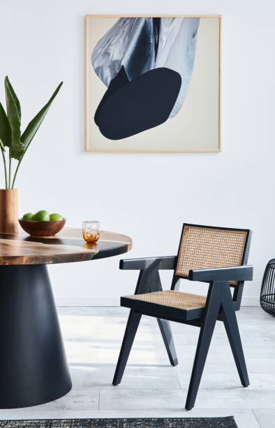 istock Stylish composition of dining room interior with design table, modern chairs, decoration, tropical leaf in vase, fruits, carpet, abstract mock up paintings and elegant accessories in home decor. 1371092446