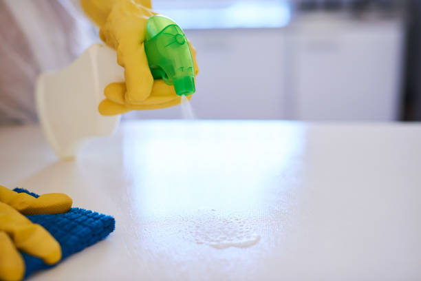istock A cleaning professional sprays a kitchen counter with sanitiser 1371094898