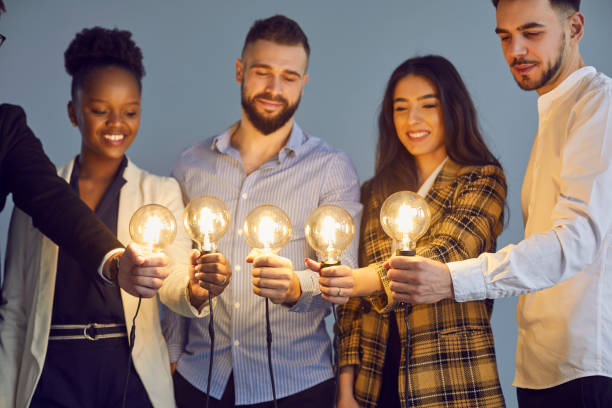 istock Diverse multinational group of people hold lightbulb together studio shot 1371094904