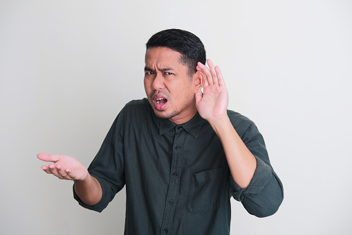 Adult Asian man showing can not hear gesture