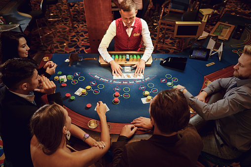 Group of people gambling sitting at a table in a casino top view