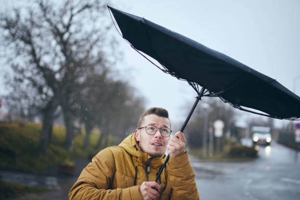istock Man with umbrella in wind and rain 1371096622