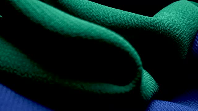 MACRO CAMERA MOVEMENT ON TWO GREEN AND BLUE CANVAS WITH A BLACK BACKGROUND