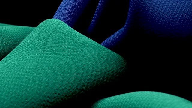MACRO CAMERA MOVEMENT ON TWO GREEN AND BLUE CANVAS WITH A BLACK BACKGROUND