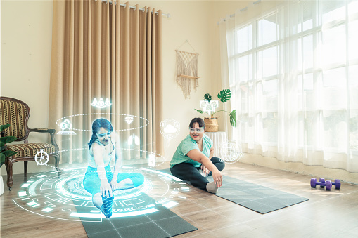 Cuidado de la salud Mujer asiática de talla grande utiliza la tecnología AR haciendo yoga de entrenamiento en casa con entrenador en metaverse juntos. photo