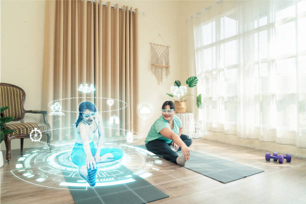 Health care Asian woman plus size use AR technology doing training yoga at home with trainer in metaverse together. stock photo