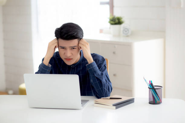 istock Young asian business man headache during working on laptop computer with deadline on desk at home, businessman with failure exhausted and tired, stress and worried, frustrated and unsuccessful. 1371102492