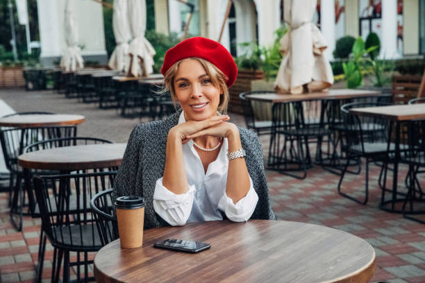 istock Beautiful woman wearing red beret drinking coffee 1371105433