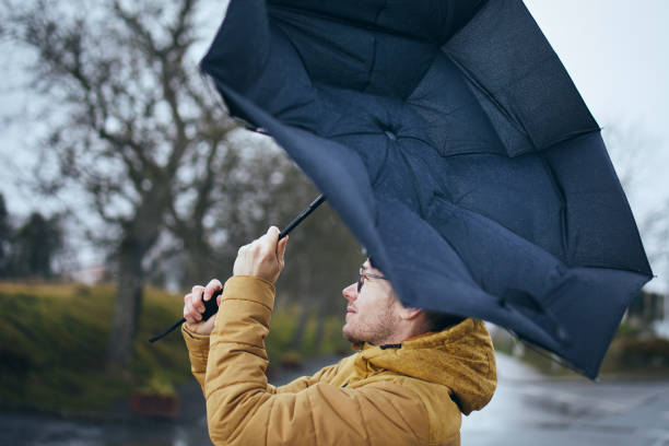 istock Man with umbrella in wind and rain 1371107115