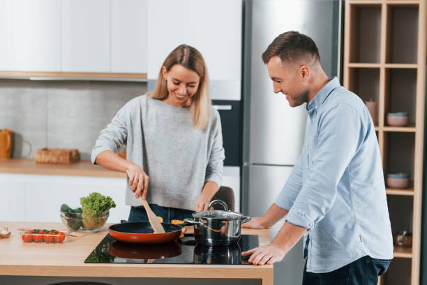 istock Delicious dinner. Couple preparing food at home on the modern kitchen 1371107751