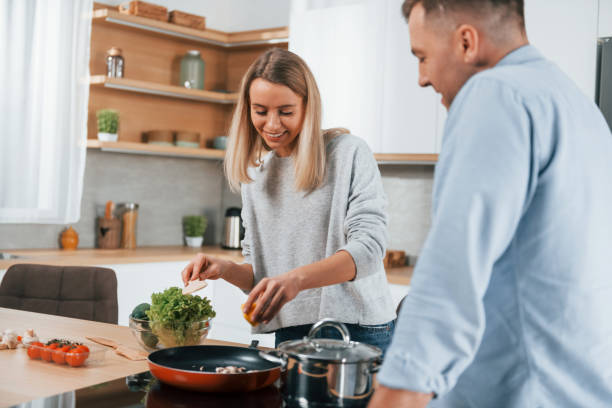 istock Delicious dinner. Couple preparing food at home on the modern kitchen 1371107773