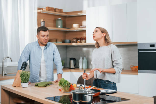 istock Arguing with each other. Couple preparing food at home on the modern kitchen 1371107880