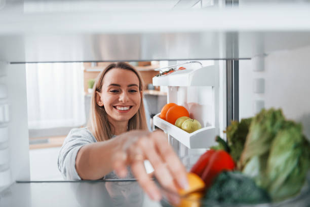 istock Happy woman taking vegetable from the fridge 1371107942