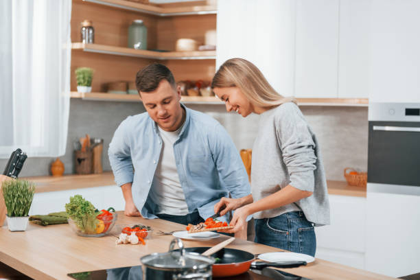 istock Using vegetables. Couple preparing food at home on the modern kitchen 1371107982