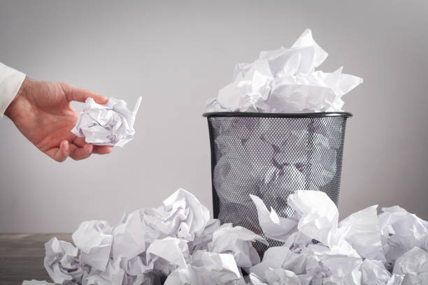 istock Man throwing crumpled paper into trash can. 1371107999