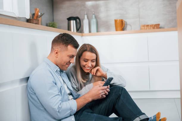 istock Couple sitting on the floor of modern kitchen 1371108169