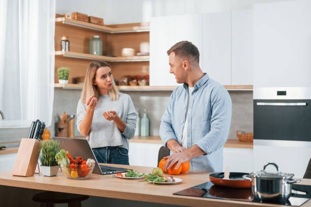 istock Having weekend together. Couple preparing food at home on the modern kitchen 1371108480
