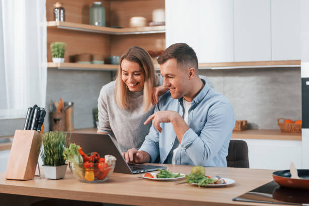 istock Having weekend together. Couple preparing food at home on the modern kitchen 1371109002