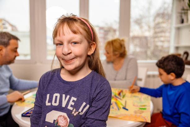 Portrait of cute girl with cleft lip, with her family behind her Portrait of girl with cleft lip, with her family behind her cleft lip stock pictures, royalty-free photos & images