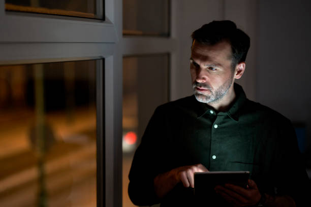 istock Adult caucasian man using digital tablet at the office and looking away 1371114061