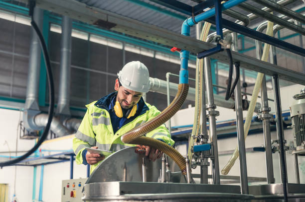 istock Caucasian technician engineer man in uniform with tablet checking and control boiler tanks and liquid pipeline in production line at factory 1371117619