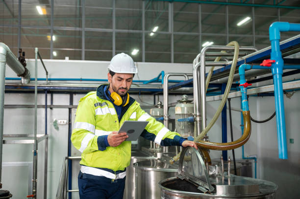 istock Caucasian technician engineer man in uniform with tablet checking and control boiler tanks and liquid pipeline in production line at factory 1371117632