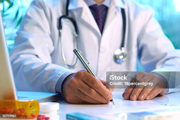 Doctor Writing Prescription Or Medical Notes Stock Photo - Download Image Now - Computer, Doctor, Document