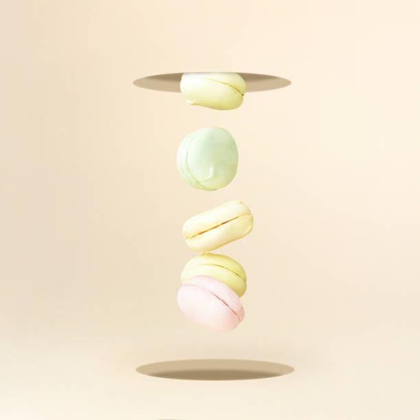 Sweet and colorful marshmallow french macaroons falling or flying in motion. Creative and moody minimal concept.