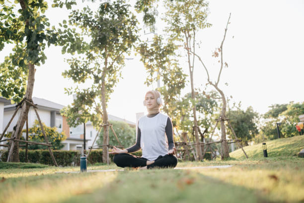 Beautiful young woman practice yoga outside at sunrise stock photo