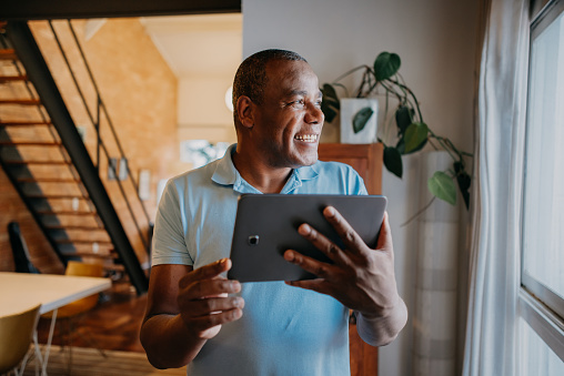 Mature man using digital tablet at home
