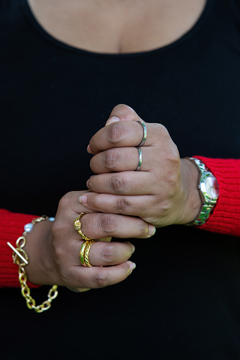 Close-up of Asian Indian woman wearing jewelry set of gold bracelet, gold and silver ring. Fashionable women's accessories.